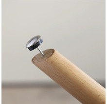 Möbelgleiter mit Nagel an einem Holzbein