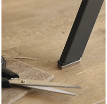 Stuhlbein mit Filzgleiter, Filzgleiter und Schere auf Boden