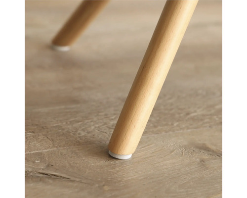 Detailaufnahme eines Möbelfußes aus Holz mit Bodenschoner.