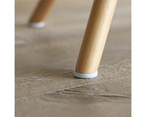 Detailansicht eines Stuhlbeins mit Bodenschoner auf einem Holzboden.