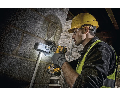 Handwerker bohrt mit Akkubohrmaschine in Mauerwerk
