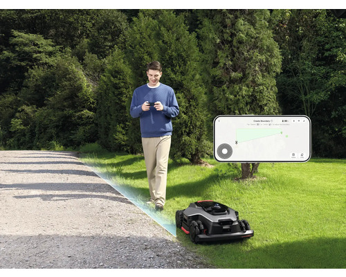 Mann steuert Mähroboter mit Smartphone im Garten