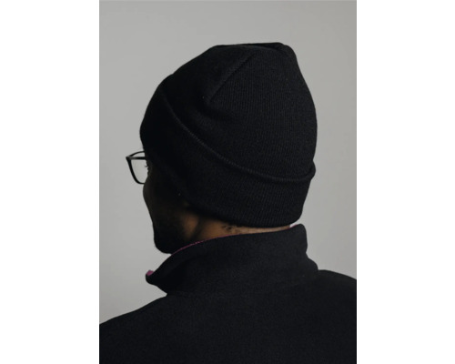 Person mit schwarzer Mütze und schwarzer Jacke von hinten