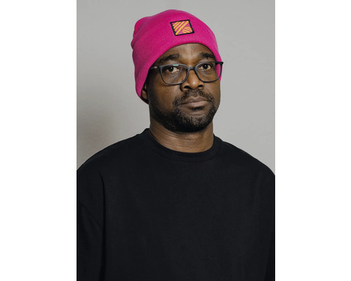 Porträt eines Mannes mit pinkfarbener Mütze und schwarzem T-Shirt