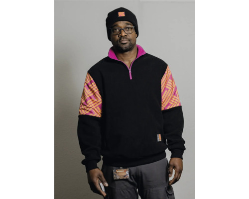 Mann mit Brille, Mütze und schwarzem Sweatshirt mit farbigen Einsätzen