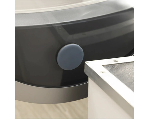 Detailansicht einer Waschmaschine mit einem runden, grauen Verschlussstopfen