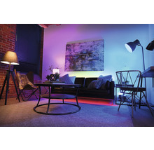 Wohnzimmer mit Sofa, Tisch, Stuhl und farbiger Beleuchtung