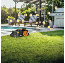Rasenmähroboter auf Rasenfläche im Garten mit Pool und Grill