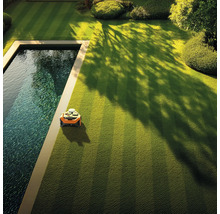 Automatische Rasenpflege im Garten mit Rasenmähroboter neben einem Pool