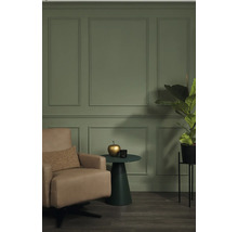 Wohnzimmer mit Sessel, Beistelltisch und Zimmerpflanze vor einer Wand mit Paneelen