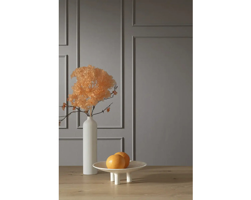 Dekorative Szene mit Trockenblumen in Vase und Obstschale auf Tisch