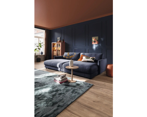 Wohnzimmer mit Sofa, Couchtisch und Teppich auf Holzboden