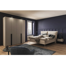 Schlafzimmer mit Bett, Kleiderschrank und Sessel auf Teppich