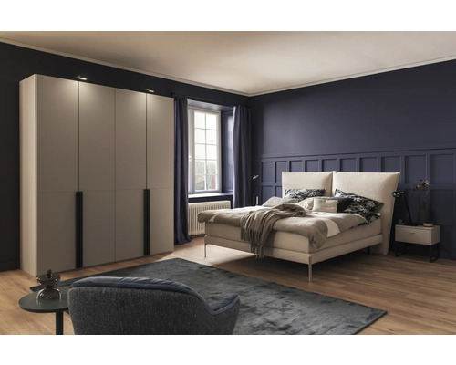 Schlafzimmer mit Bett, Kleiderschrank und Sessel auf Teppich