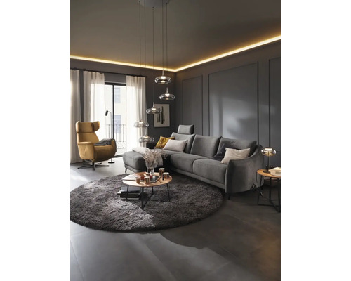 Wohnzimmer mit Sofa, Sessel, Teppich und Pendelleuchten