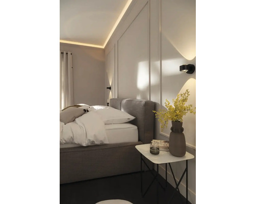 Schlafzimmer mit Bett, Nachttisch und Wandleuchten