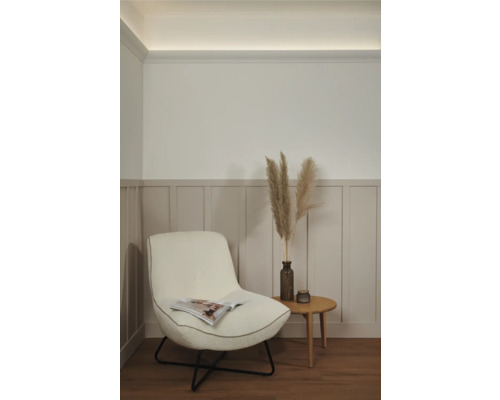 Wohnzimmerszene mit Sessel, Beistelltisch und Dekoration für gemütliches Ambiente