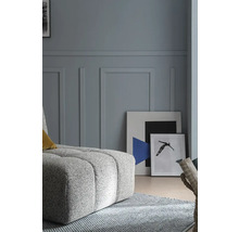 Wohnzimmer mit Polsterhocker, Teppich und Bildern an der Wand