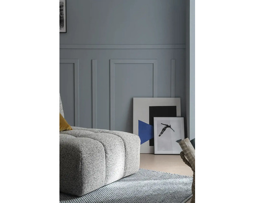 Wohnzimmer mit Polsterhocker, Teppich und Bildern an der Wand