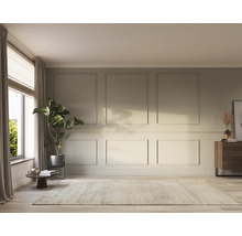 Heller Wohnraum mit Teppich, Kommode und Zimmerpflanze vor einem Fenster