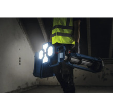 Handwerker trägt Baustellenstrahler