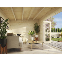 Innenansicht eines Holzgartenhauses mit Couch, Pflanzen und geöffneter Tür zum Garten