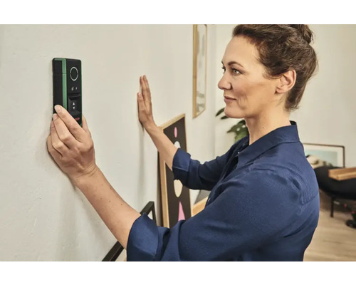 Frau verwendet einen Wandscanner zur Ortung von Objekten in einer Wand