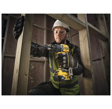 Handwerker bohrt mit einer DeWalt Akku-Bohrmaschine ein Holzbrett