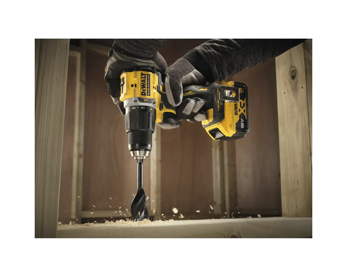 Eine Person bohrt mit einem gelben Akku-Bohrschrauber von DeWalt ein Loch in ein Holzstück.