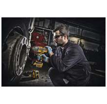 Ein Mann benutzt einen Akku-Schlagschrauber an einem Fahrzeugreifen in einer Werkstatt.