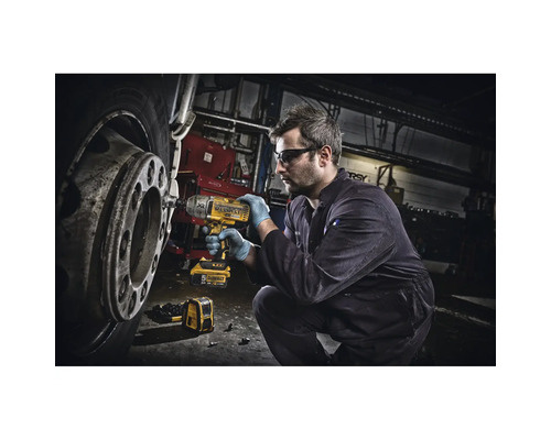 Ein Mann benutzt einen Akku-Schlagschrauber an einem Fahrzeugreifen in einer Werkstatt.