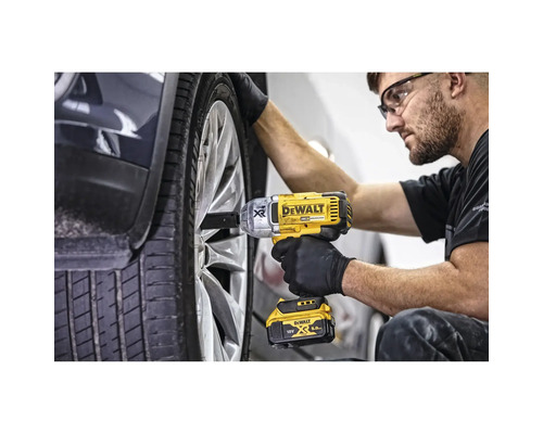 Ein Mechaniker verwendet einen gelben Akku-Schlagschrauber von DeWalt, um ein Rad an einem Fahrzeug zu befestigen.