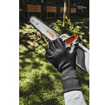 Eine Hand mit Handschuh hält eine Stihl Akku-Kettensäge.