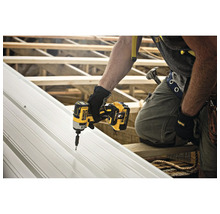 Ein Handwerker befestigt eine Metallplatte mit einem Akku-Schlagschrauber von Dewalt.