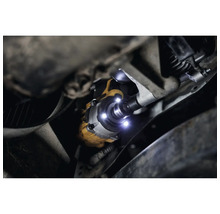 Blick unter ein Auto mit leuchtendem Schlagschrauber der Marke DeWalt