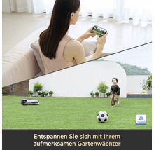 Szene mit Frau, die auf einer Couch sitzt und ihr Handy benutzt, Kind, das auf einer Wiese spielt, Rasenmähroboter und TÜV Rheinland zertifiziert Siegel