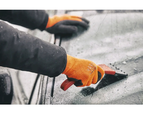 Person mit Handschuhen benutzt einen Eiskratzer an einer Windschutzscheibe
