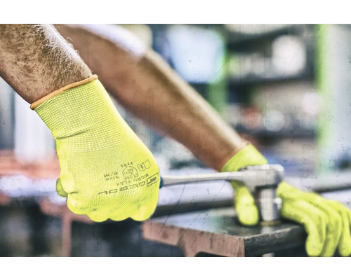 Mann mit gelben Arbeitshandschuhen benutzt einen Schraubenschlüssel