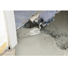 Handwerker glättet Ausgleichsmasse mit einer Glättkelle.