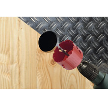 Bohrmaschine mit Lochsäge bohrt ein Loch in ein Holzbrett