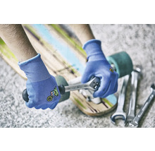 Person repariert Skateboard mit Schraubenschlüssel und Handschuhen