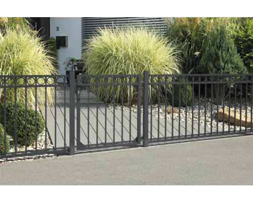 Metallzaun mit runden Zierelementen vor einem Haus