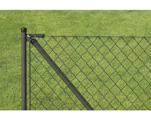 Detailansicht eines Maschendrahtzauns mit Pfosten vor grünem Rasen