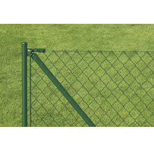 Detailansicht eines Maschendrahtzauns mit Zaunpfosten vor Rasenfläche