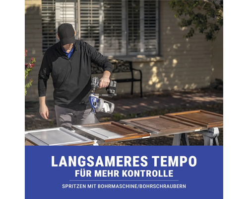 Mann lackiert Schranktüren mit Farbspritzgerät für Bohrmaschine