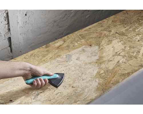 Eine Hand hält einen Schleifklotz und schleift eine Holzplatte.