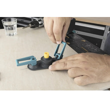 Ein Mann bedient einen Lochsägen-Kreisschneider auf einer Holzoberfläche