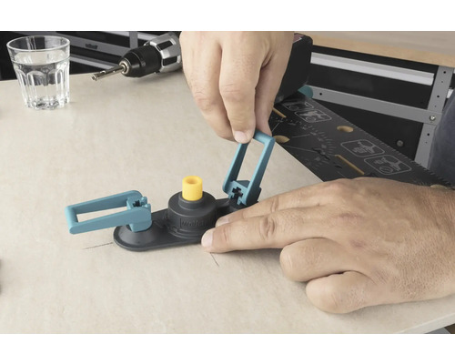 Ein Mann bedient einen Lochsägen-Kreisschneider auf einer Holzoberfläche