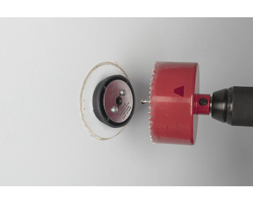 Eine Lochsäge bohrt ein Loch in eine Wand.