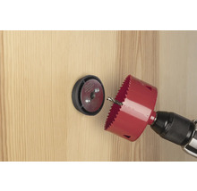 Lochsäge mit Bohrmaschine bohrt ein Loch in eine Holztür